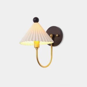 Off-white pleated ceramic wall sconce with brass metal arm and dark wood mounting bracket against pure white wall