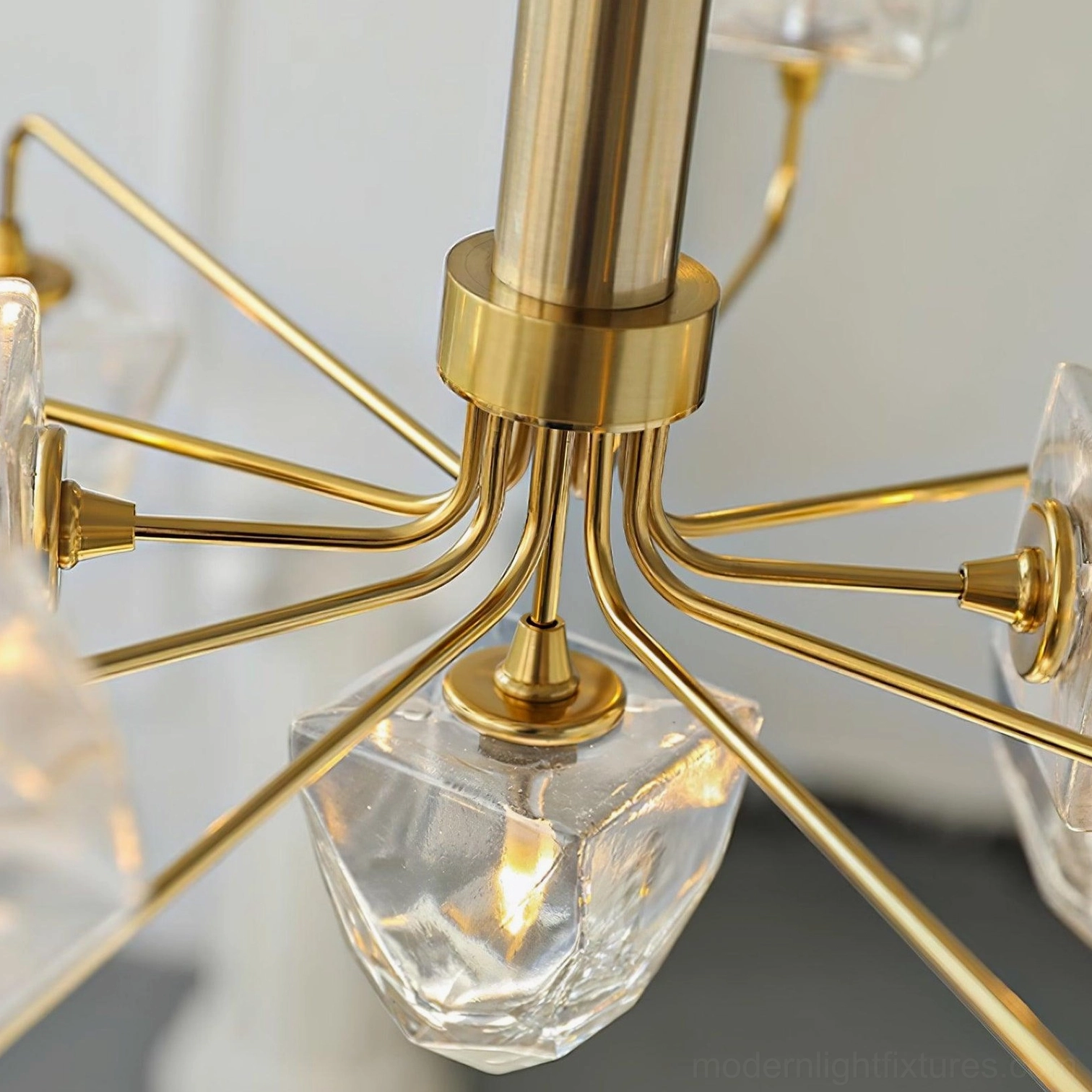Modern glass chandelier showing suspension rod and hanging mechanism in residential ceiling installation