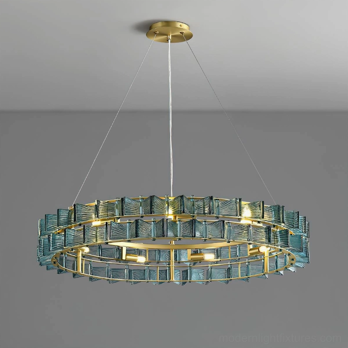 Contemporary ring light fixture overhead shot showing illuminated teal glass and suspension cables