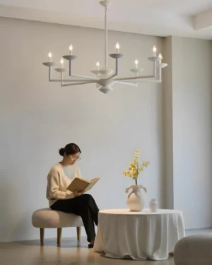 White multi-arm pendant chandelier installed in minimalist residential lounge, low-angle interior photography