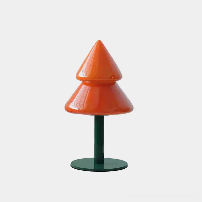 Modern Christmas tree table lamp with bright orange glossy shade and dark green metal base on white studio background