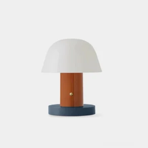 White frosted cordless mushroom table lamp with terracotta stem and dark blue base on minimalist studio background