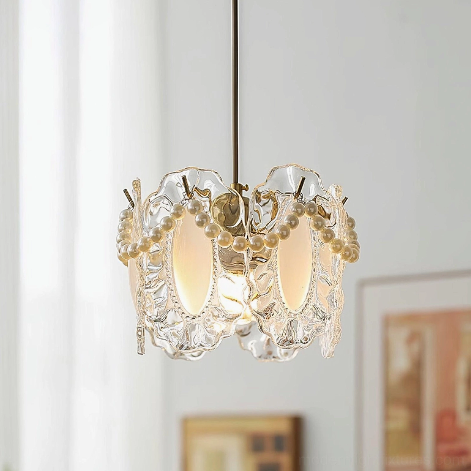 Elegant crystal pearl pendant light illuminated in warm glow above dining table with sheer curtains and wall art