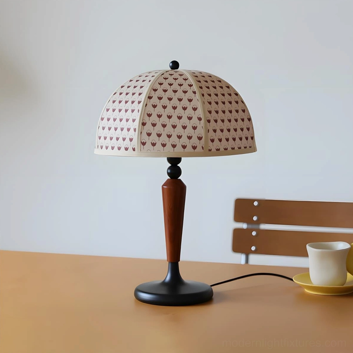 Modern dome table lamp three-quarter view on wooden desk with coffee mug and saucer