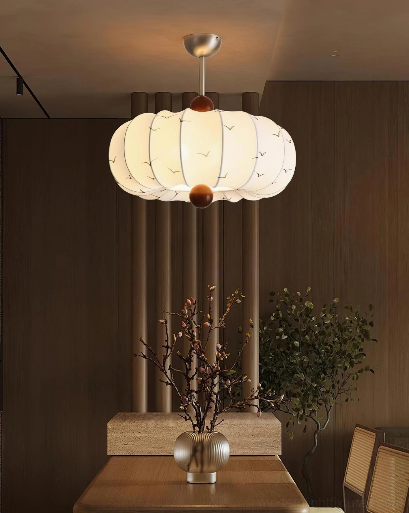 Bird Song pendant light installed in warm dining room with rustic wooden interior - modern ceiling fixture casting warm ambient glow