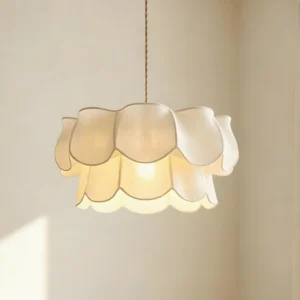 Modern petal pendant light hanging in contemporary interior with warm ambient glow, close-up front view of scalloped fabric shade and warm white LED lighting