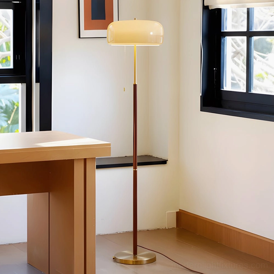Modern floor lamp with mushroom shade and wood stem in home office with wooden desk and black window