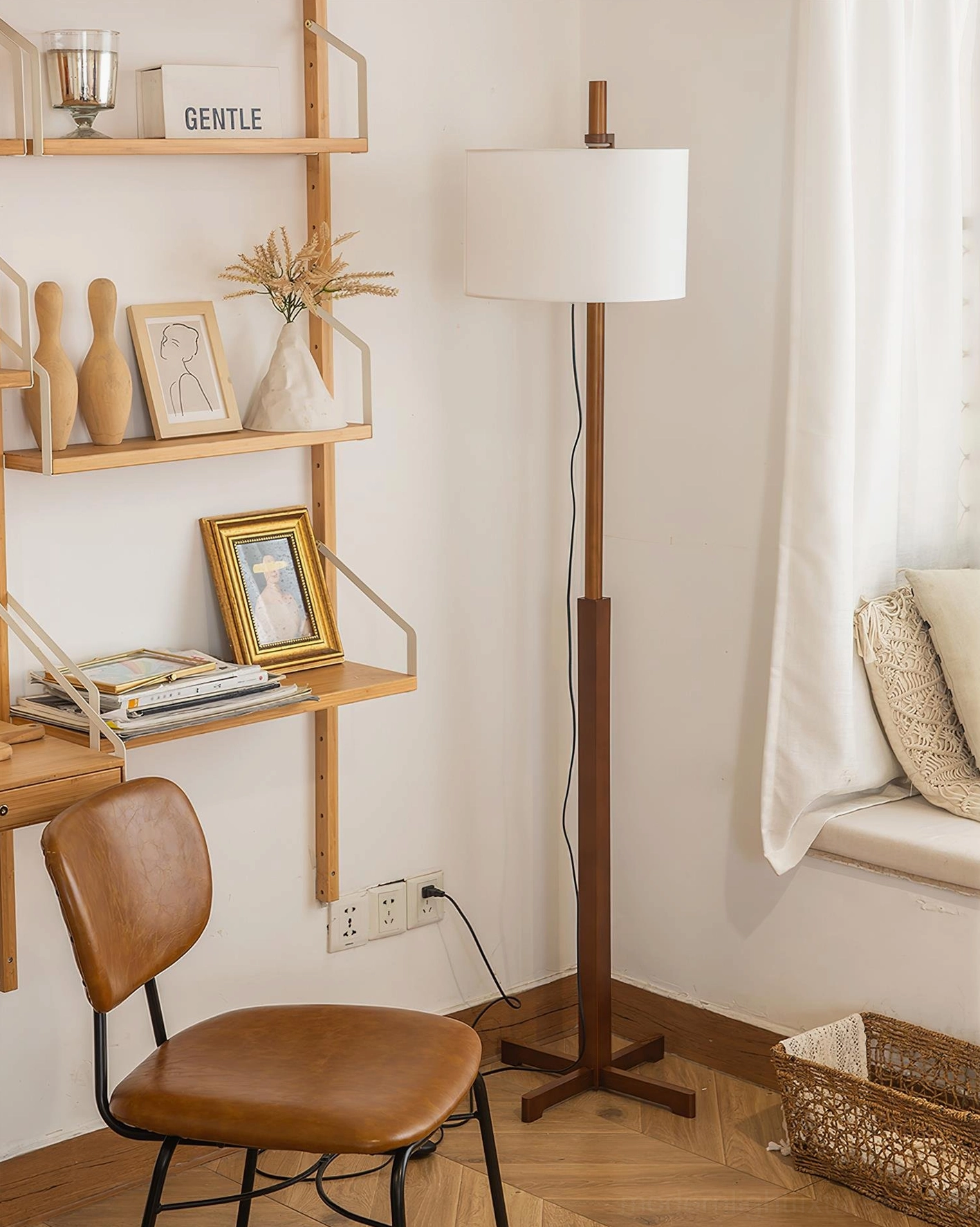 Contemporary wooden floor lamp positioned beside window workspace with floating shelves and wicker storage basket