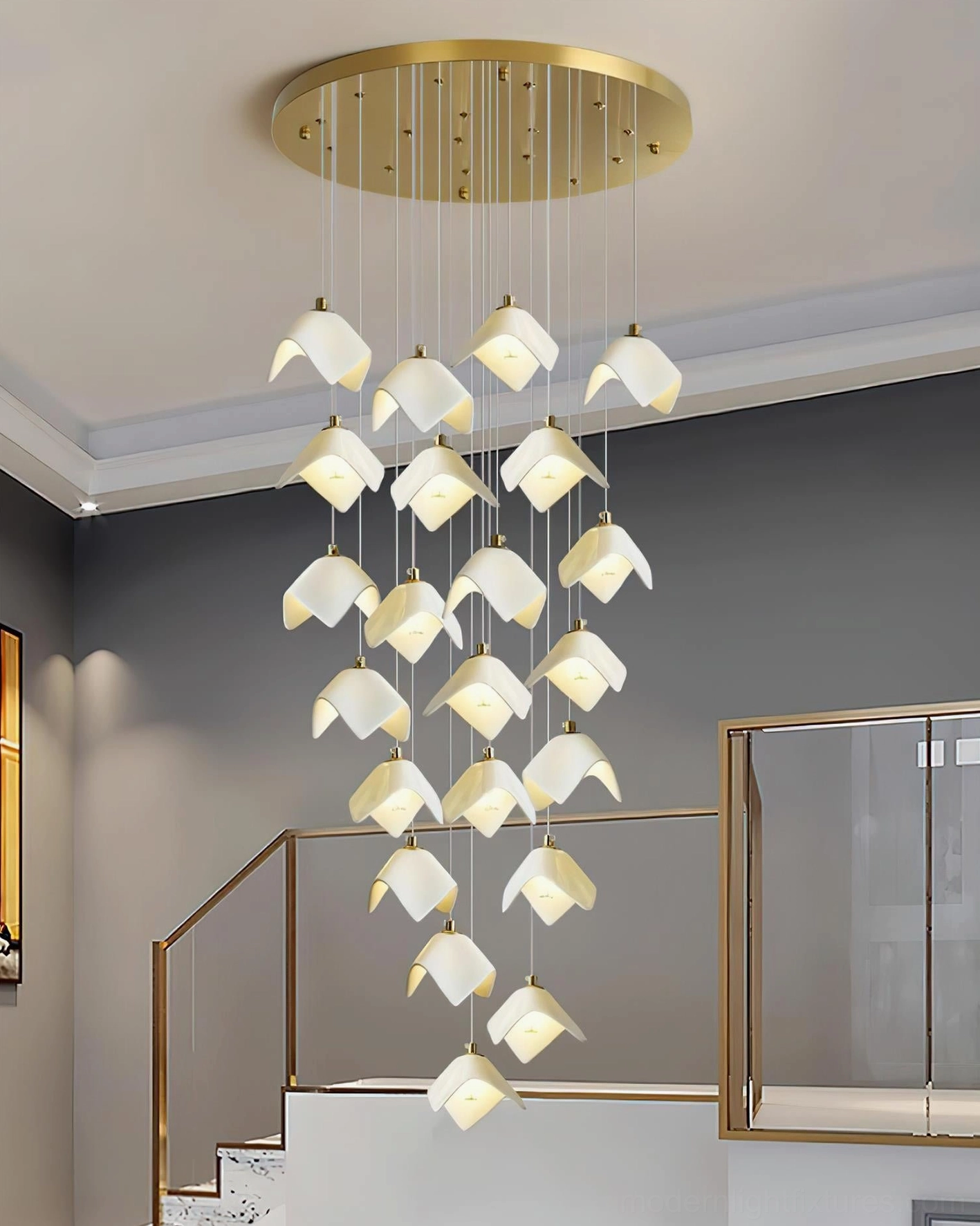 Cascading Bloom chandelier installed in modern duplex stairwell casting warm glowing light through tiered bell shades