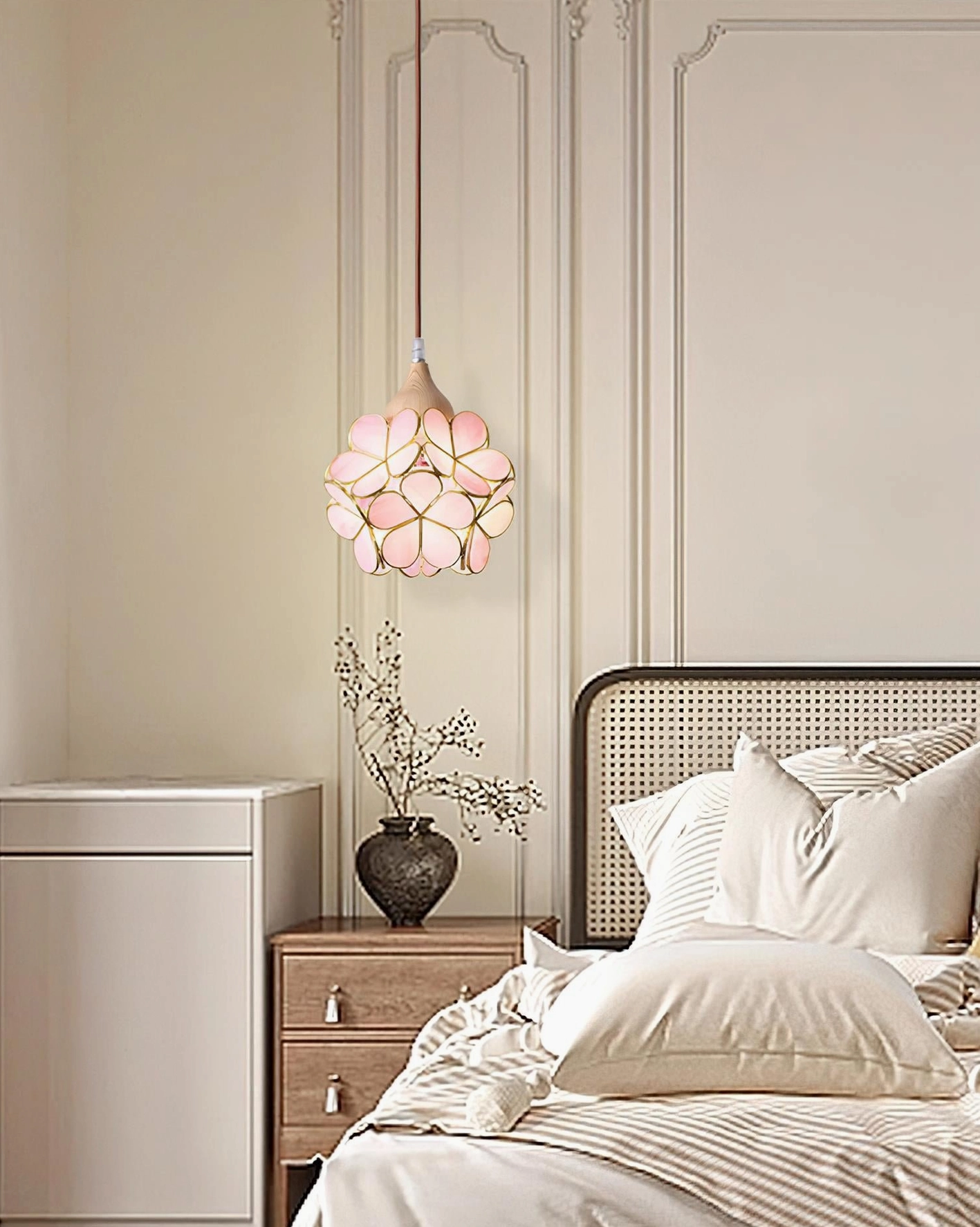 Modern floral pendant light fixture in bedroom setting, showcasing pink glass shade with warm glowing ambiance