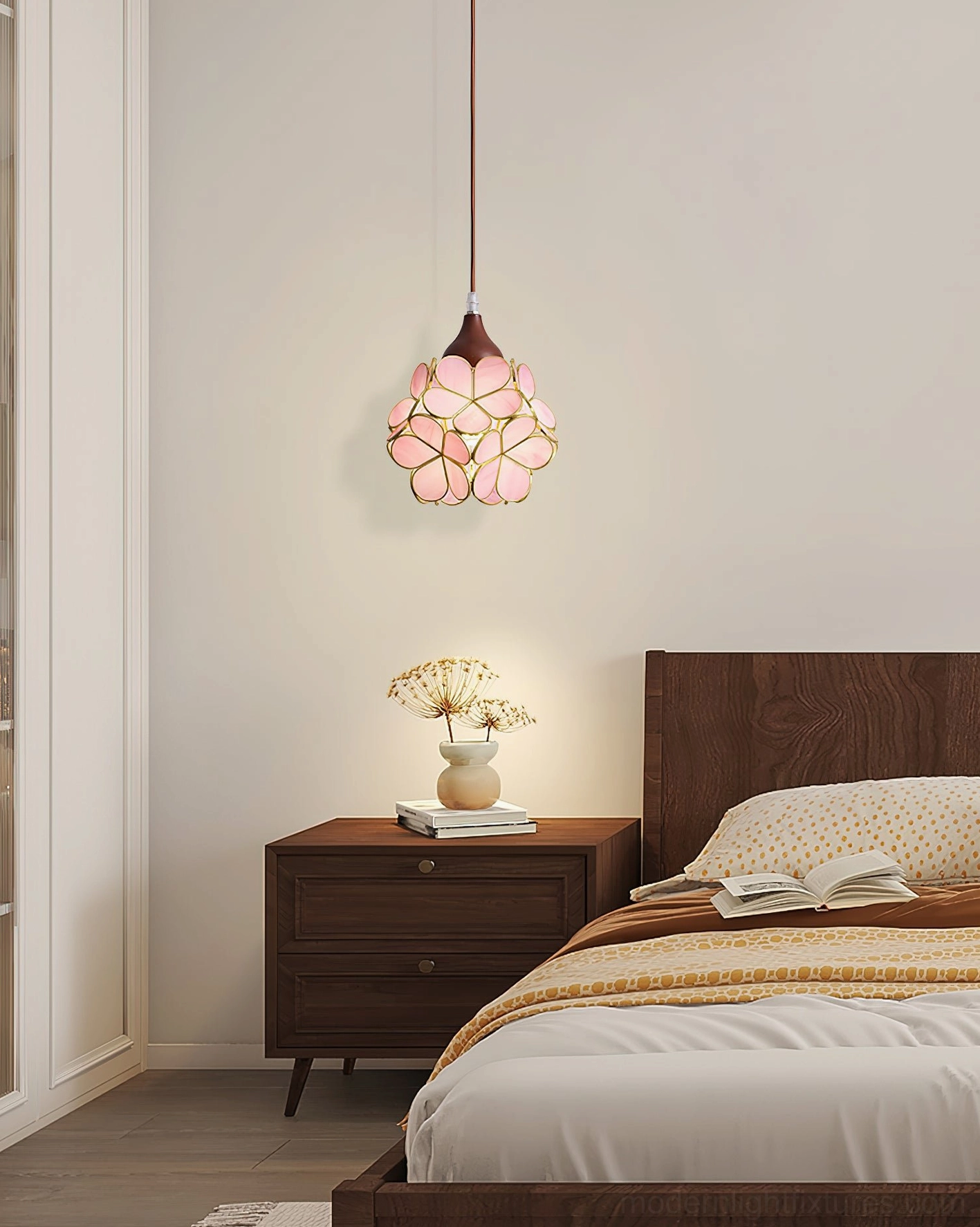Stained glass flower pendant hanging in modern warm bedroom with dark wood nightstand and glowing pink shade