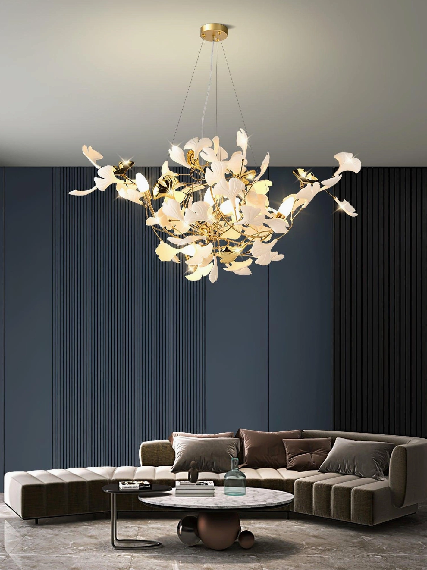 Modern ginkgo leaf chandelier overhead view - white ceramic leaves on gold frame above sectional sofa in contemporary living room