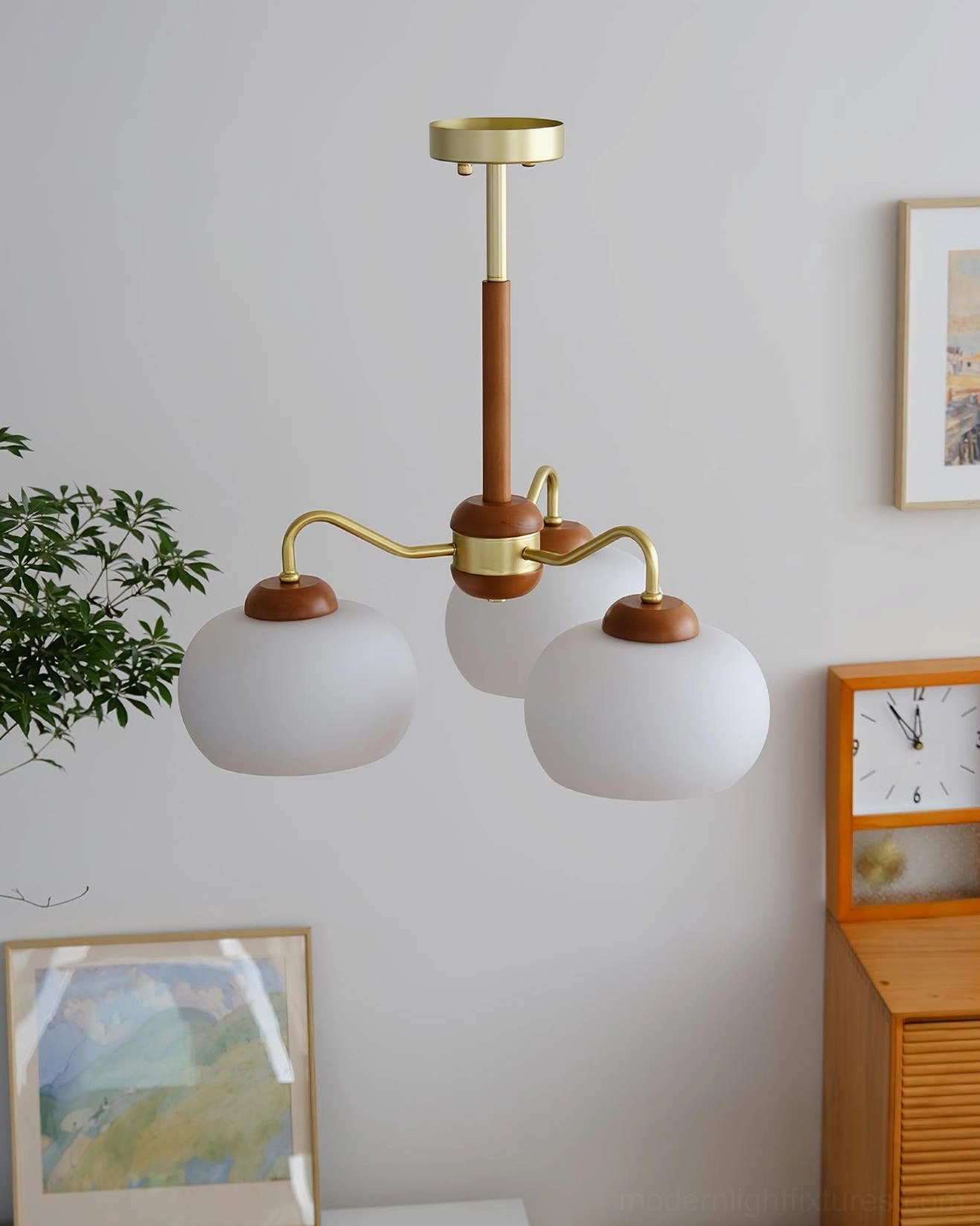 Contemporary Nordic pendant light with frosted glass shades and brass accents displayed in minimalist living space