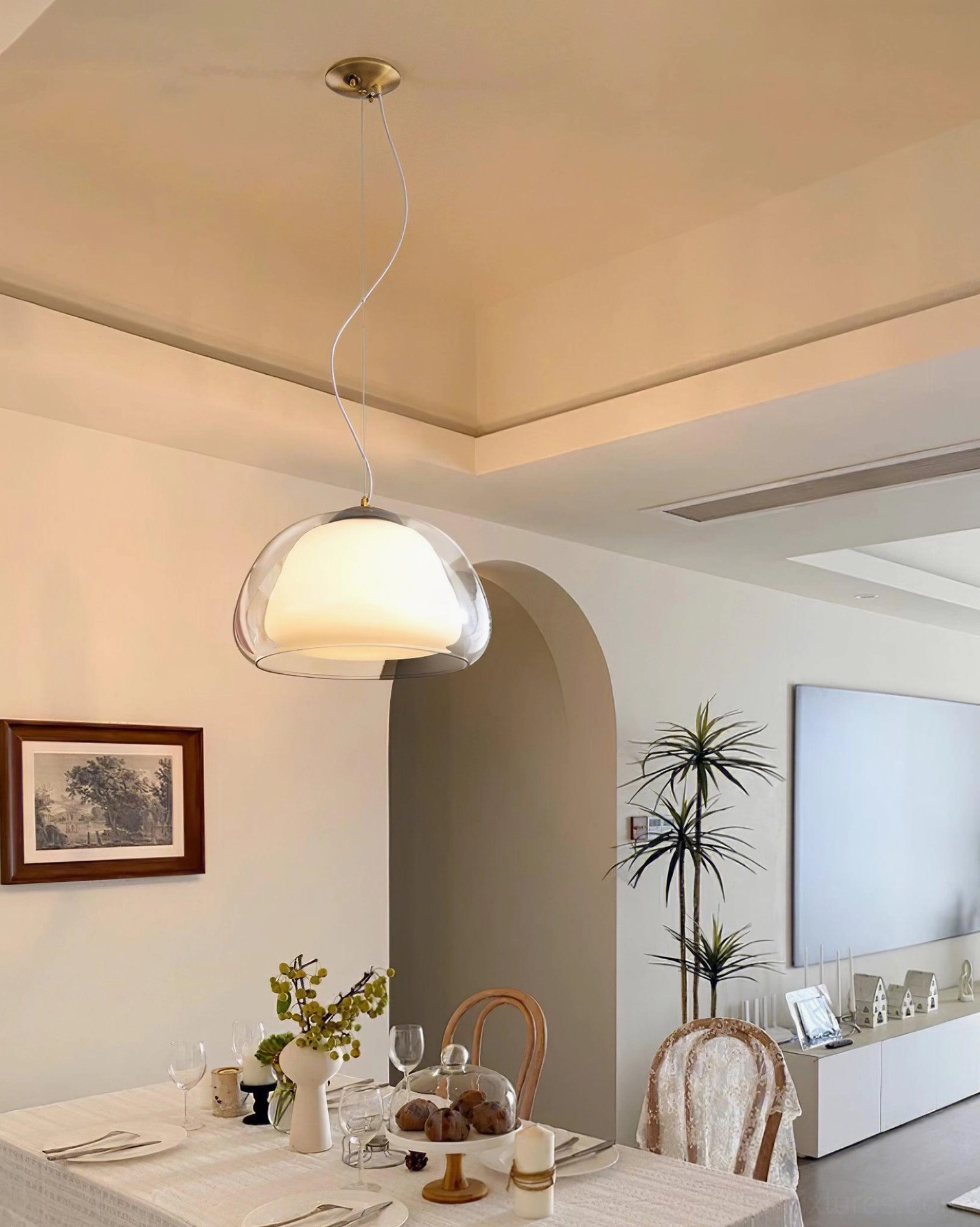 Minimalist glass pendant light in warm living-dining space with arched doorway and contemporary furniture