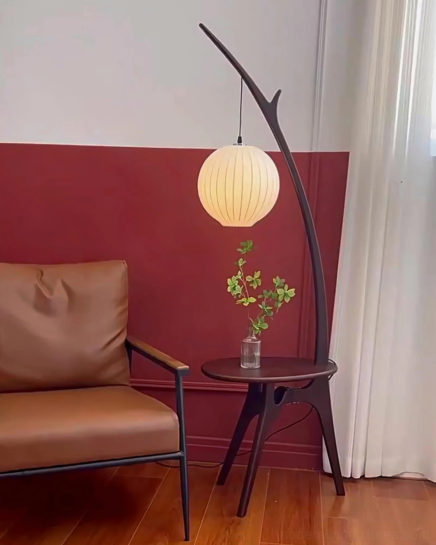 Modern handcrafted floor lamp with side table and curved branch-style pole in minimalist space
