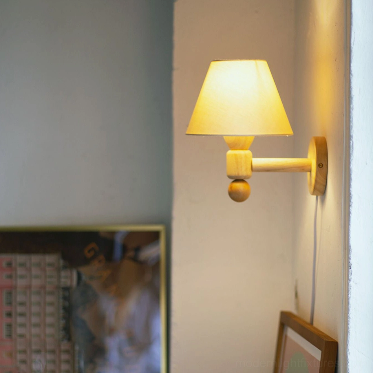 Illuminated geometric wall sconce with warm glowing beige shade and solid wood hardware detail close-up view