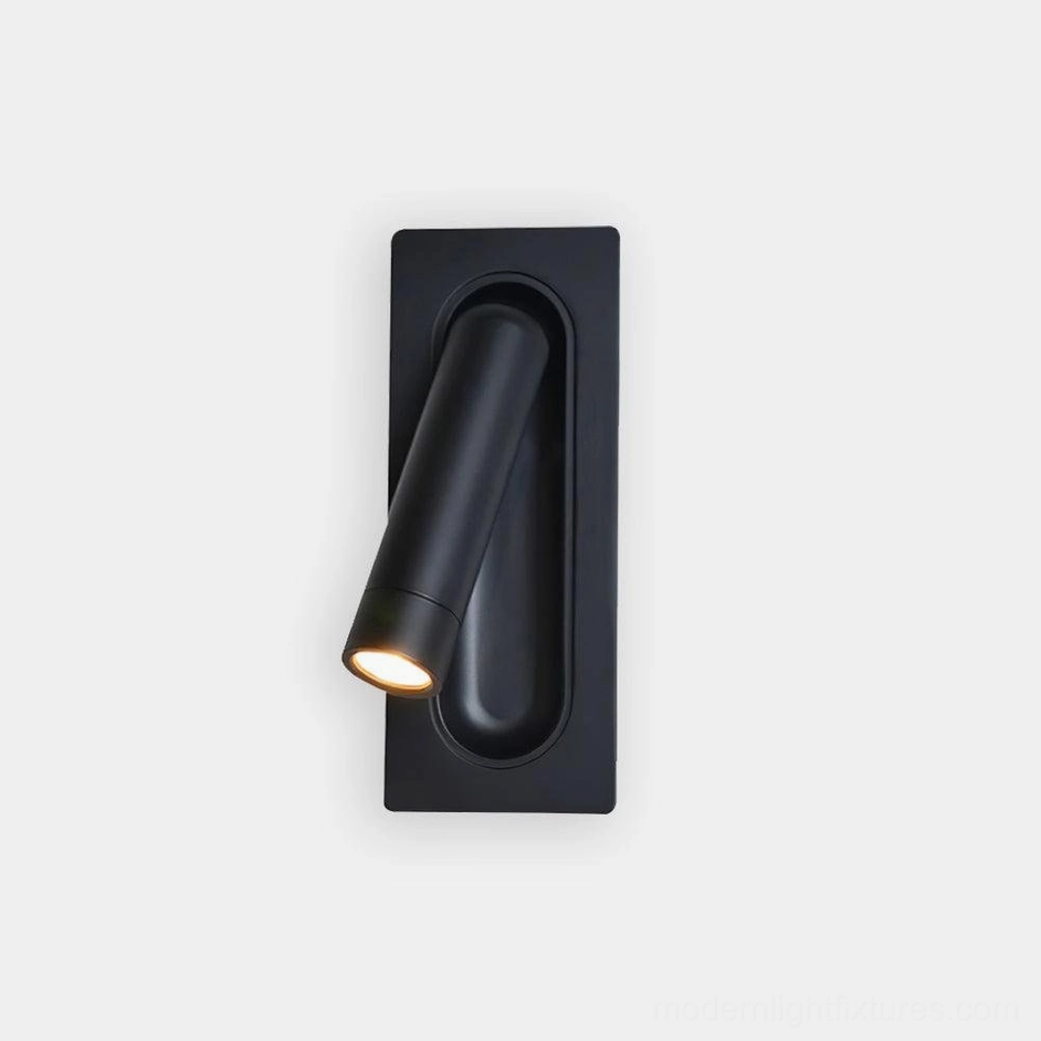 Modern recessed LED wall reading lamp with matte black finish, studio front close-up showing compact cylindrical design and flush mounting