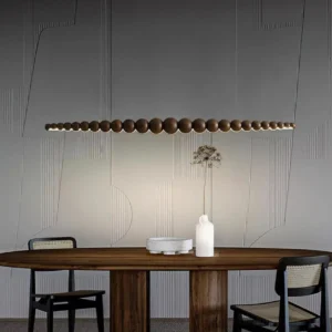 Filamento linear chandelier installed above dining table in modern dining room with textured wall feature