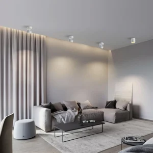 Multiple white surface mounted spotlights installed on ceiling in modern minimalist living room with warm ambient lighting