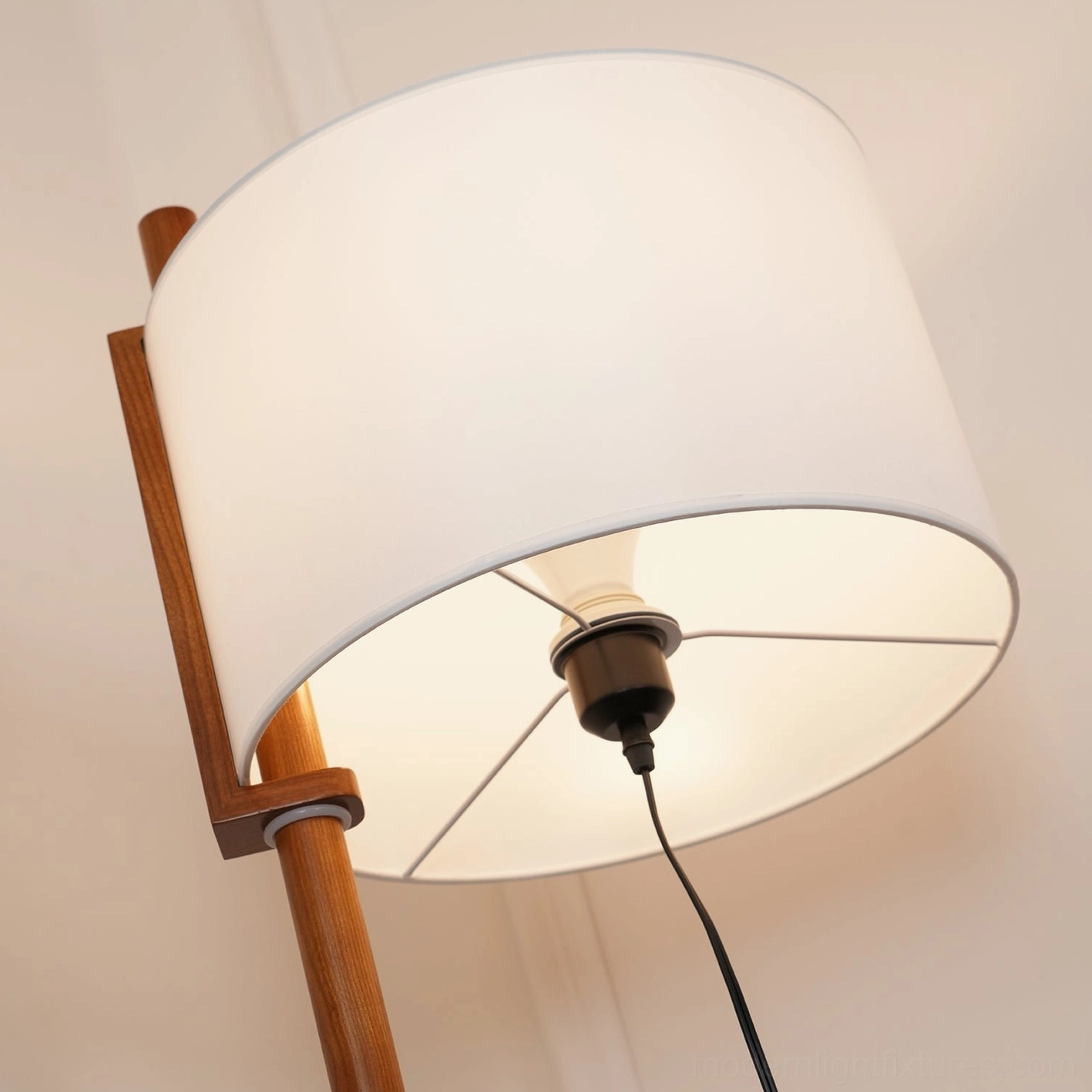 Modern mid-century floor lamp in bright studio setting, full view of walnut pole and white cylindrical shade design