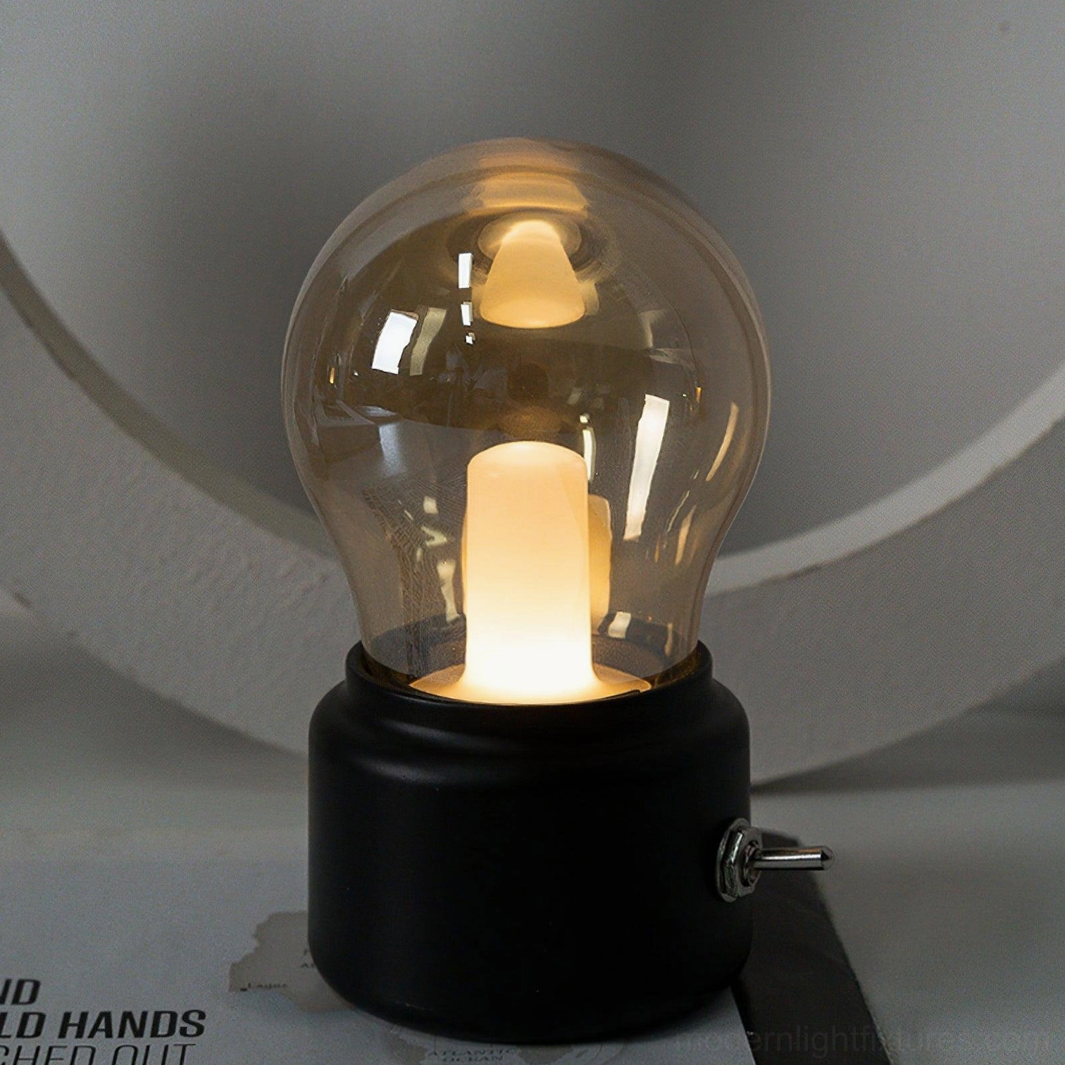 Modern small table lamp with black matte base and smoked glass bulb shade