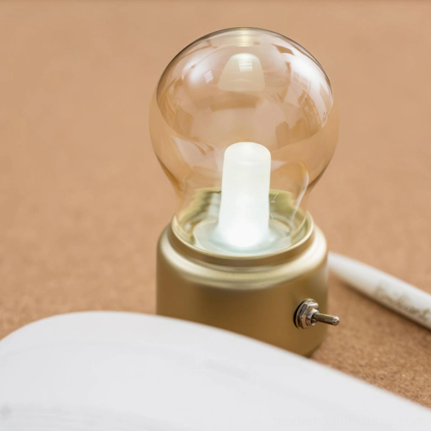Champagne gold compact bulb lamp with cool white LED light on minimalist desktop setup