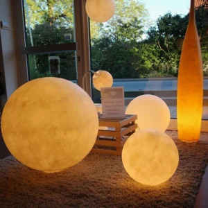 Multiple size moon floor lamps in outdoor patio Nordic minimalist garden setting with warm glow
