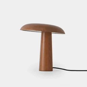 Modern mushroom table lamp with natural wood base and warm ambient lighting, front low-angle studio view