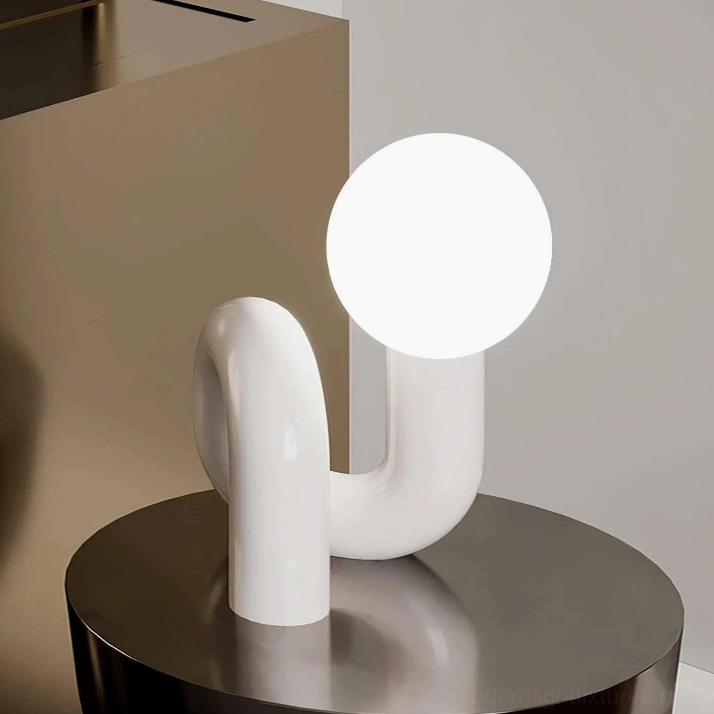 Contemporary N-shaped table lamp with white ceramic base and illuminated frosted glass sphere, interior setting