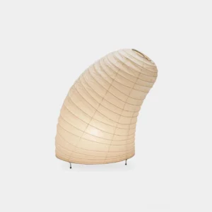 Modern minimalist table lamp with ribbed off-white rice paper shade and black metal legs, studio front three-quarter view
