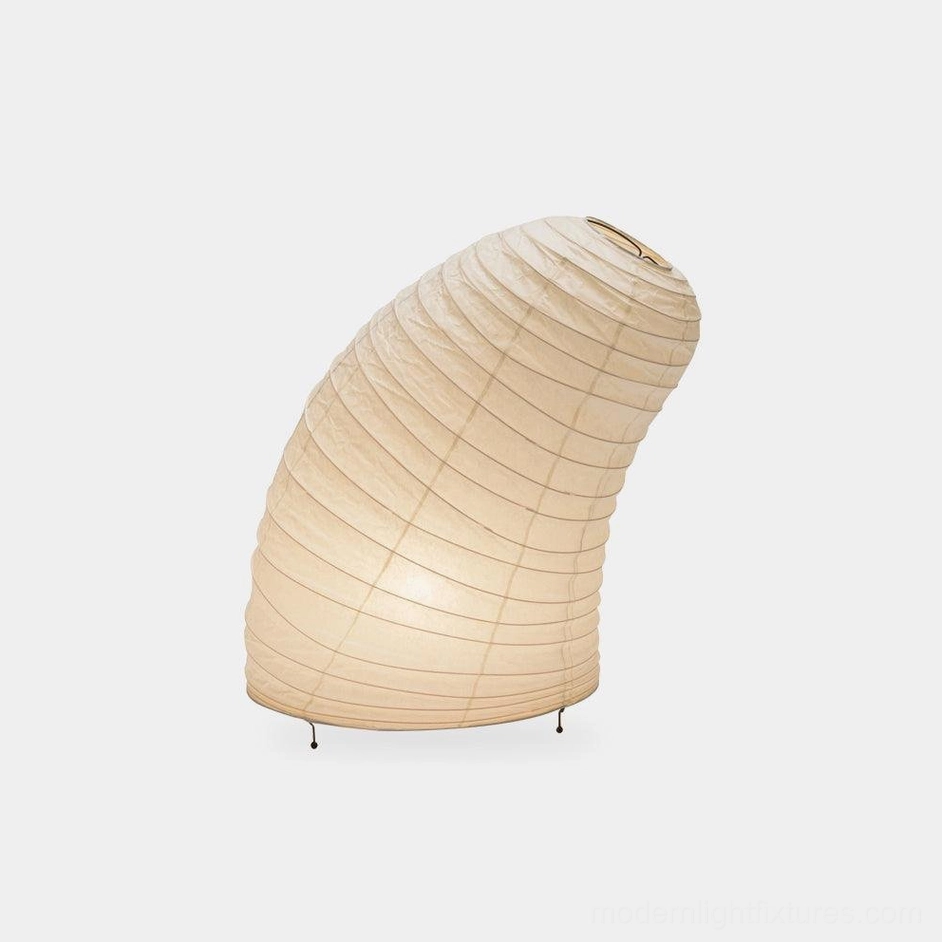 Modern minimalist table lamp with ribbed off-white rice paper shade and black metal legs, studio front three-quarter view