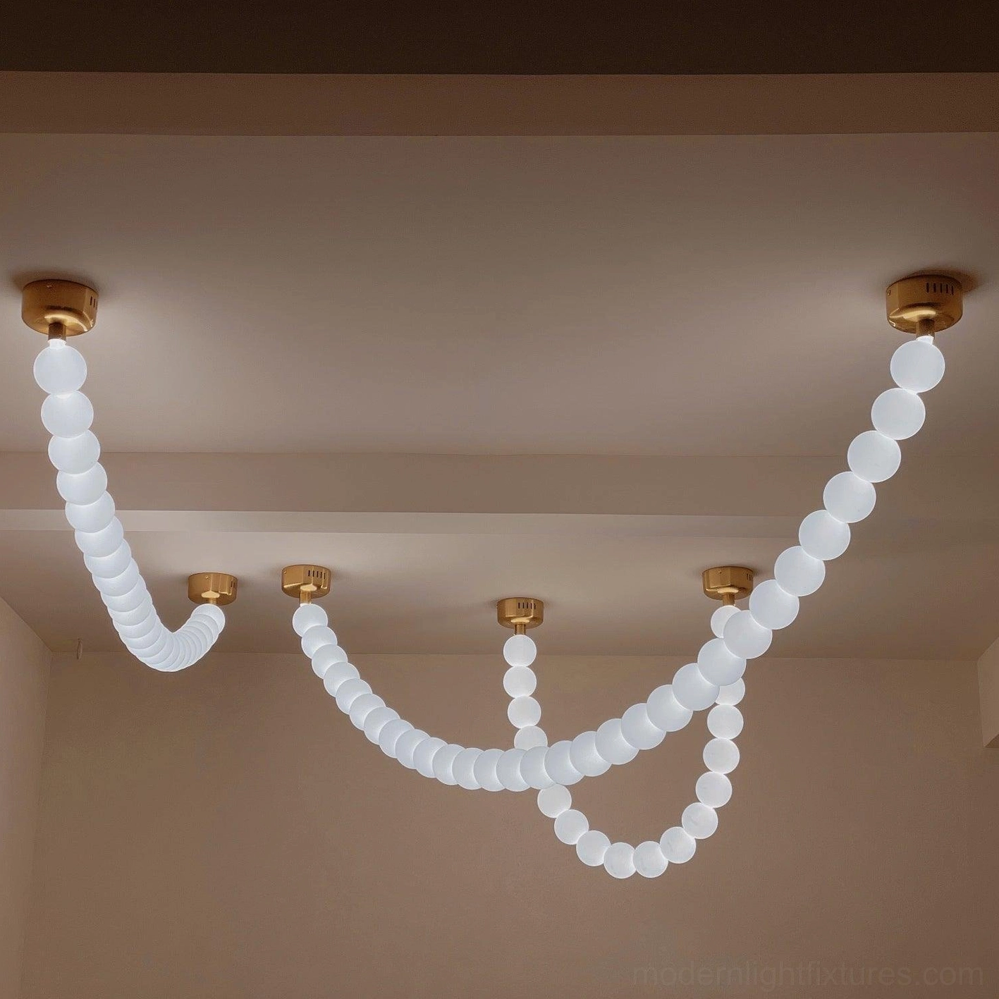 Modern pearl string light fixture with multiple illuminated acrylic orbs in sophisticated arrangement