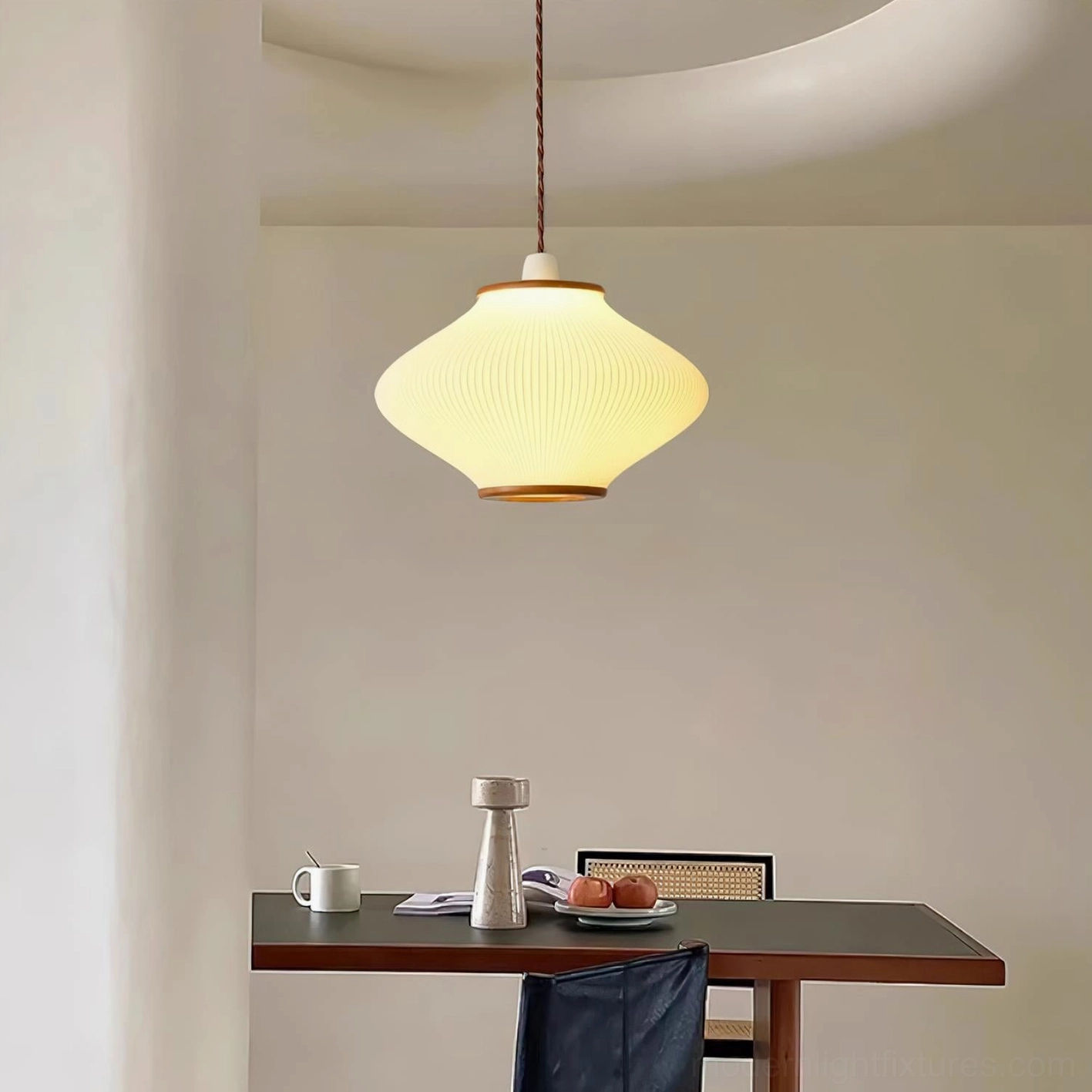 Minimalist biconical pendant light over dark wooden dining table in contemporary home setting