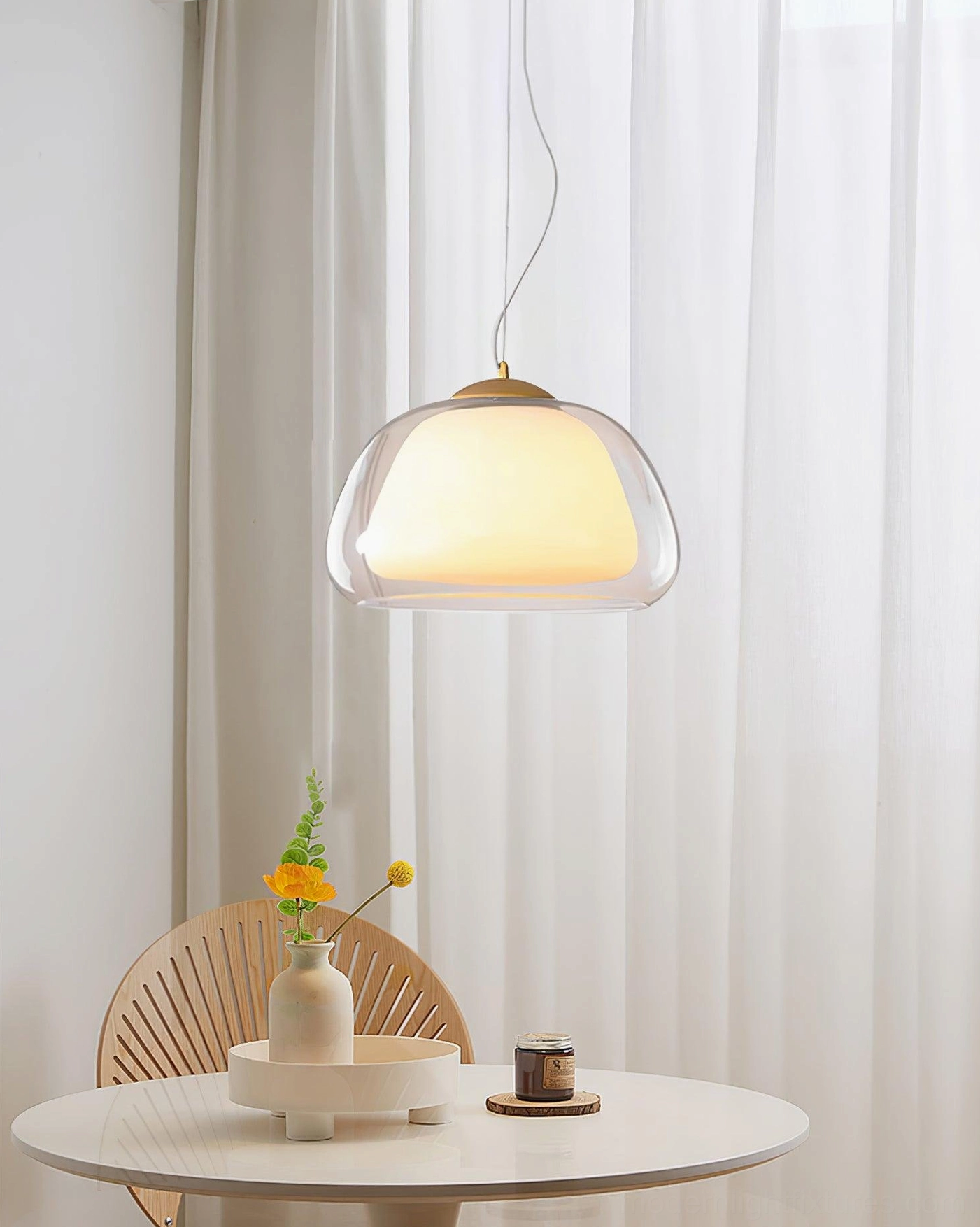 Modern minimalist glass pendant light fixture displaying warm ambient glow and frosted inner shade design