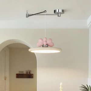 Contemporary pendant lamp installed in creamy residential entryway with pink heart bow decoration on beige shade
