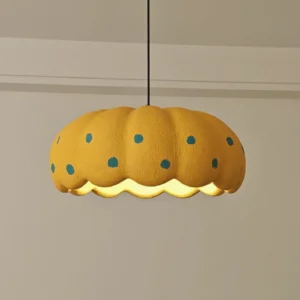 Illuminated modern pendant light with warm glow, yellow resin shade with blue polka dot pattern