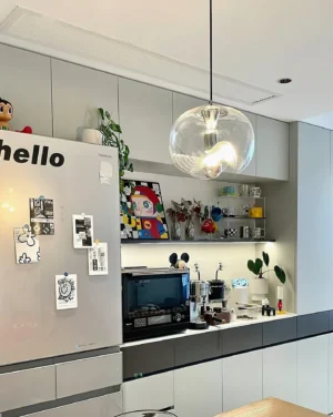 Contemporary pendant light installed in residential kitchen, eye-level view showcasing modern minimalist design with polished metal hardware and clear glass