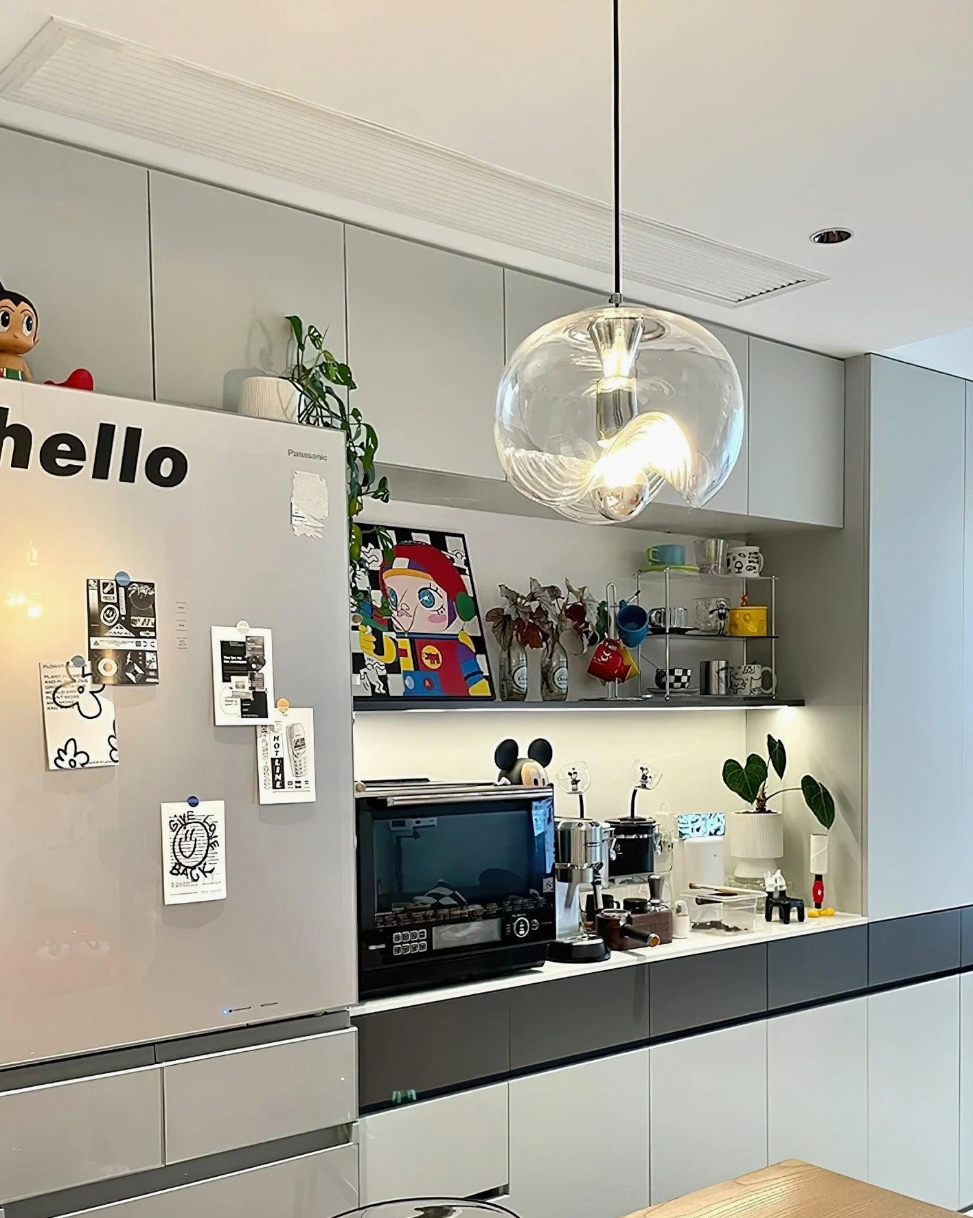 Contemporary pendant light installed in residential kitchen, eye-level view showcasing modern minimalist design with polished metal hardware and clear glass