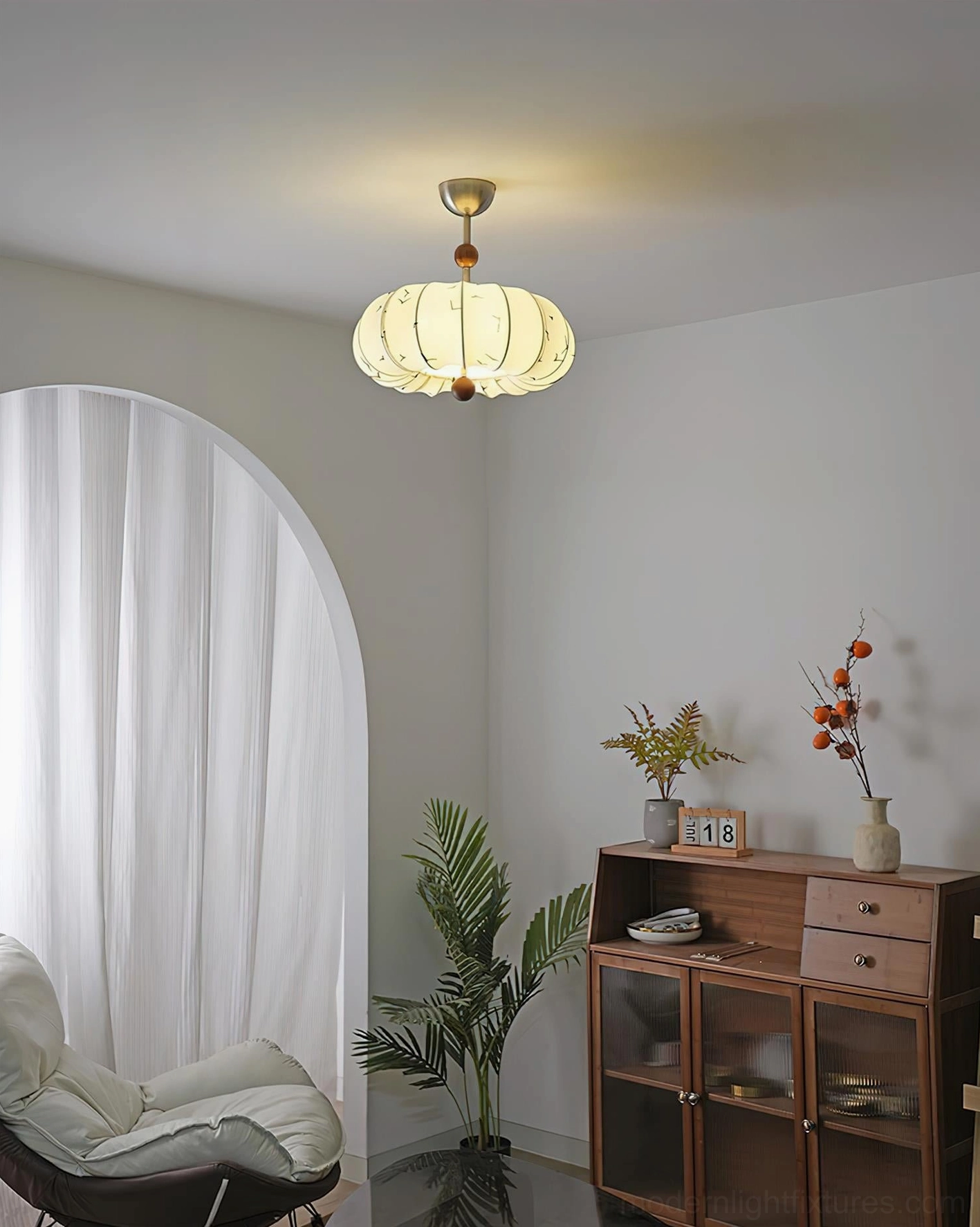 Modern pendant ceiling fixture installed in minimalist living room - distant view showing warm light in neutral contemporary interior design