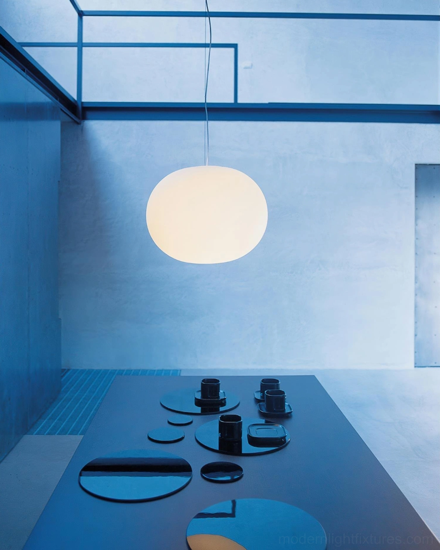 Contemporary minimalist sphere pendant lighting in modern loft - overhead view showing pure white frosted glass shade with skylight