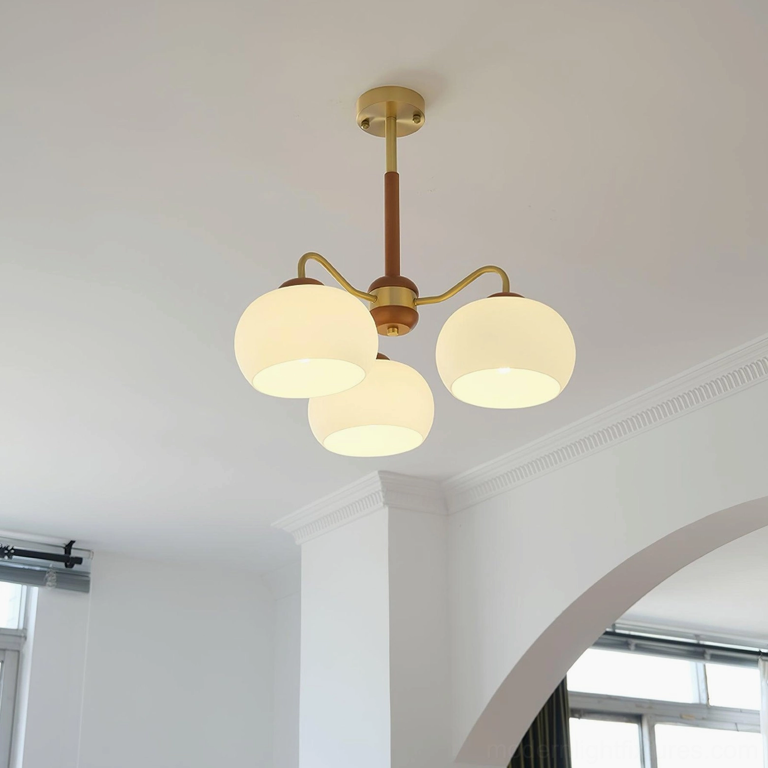 Modern pendant light fixture with teak wood frame and polished brass accents frosted glass shades