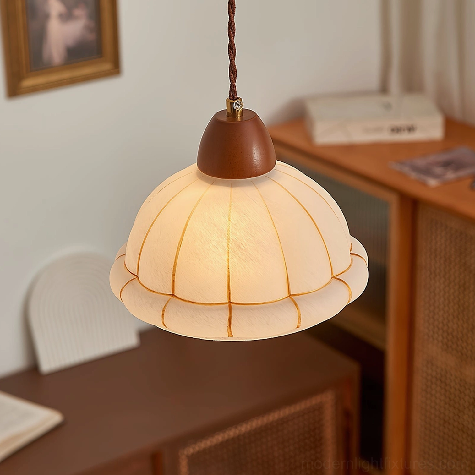 Pendant lamp with twisted brown cable in home workspace with wooden desk furniture