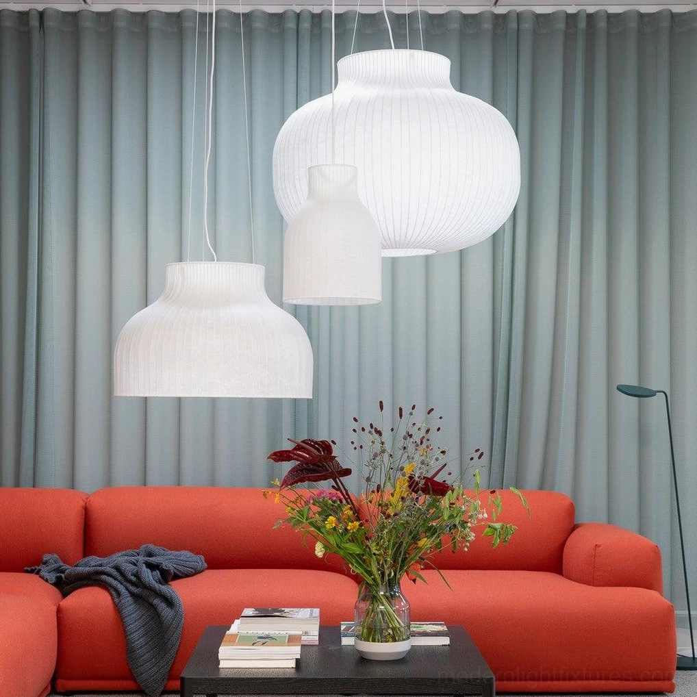 Multiple white ribbed fabric pendant lamps with layered hanging arrangement in minimalist living room
