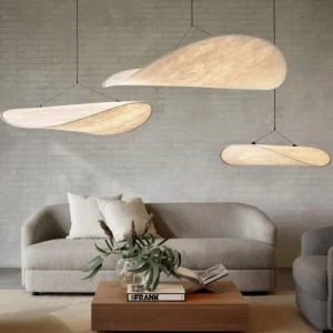Tense pendant lights installed in modern living room with grey fabric sofa and brick accent wall, warm ambient lighting