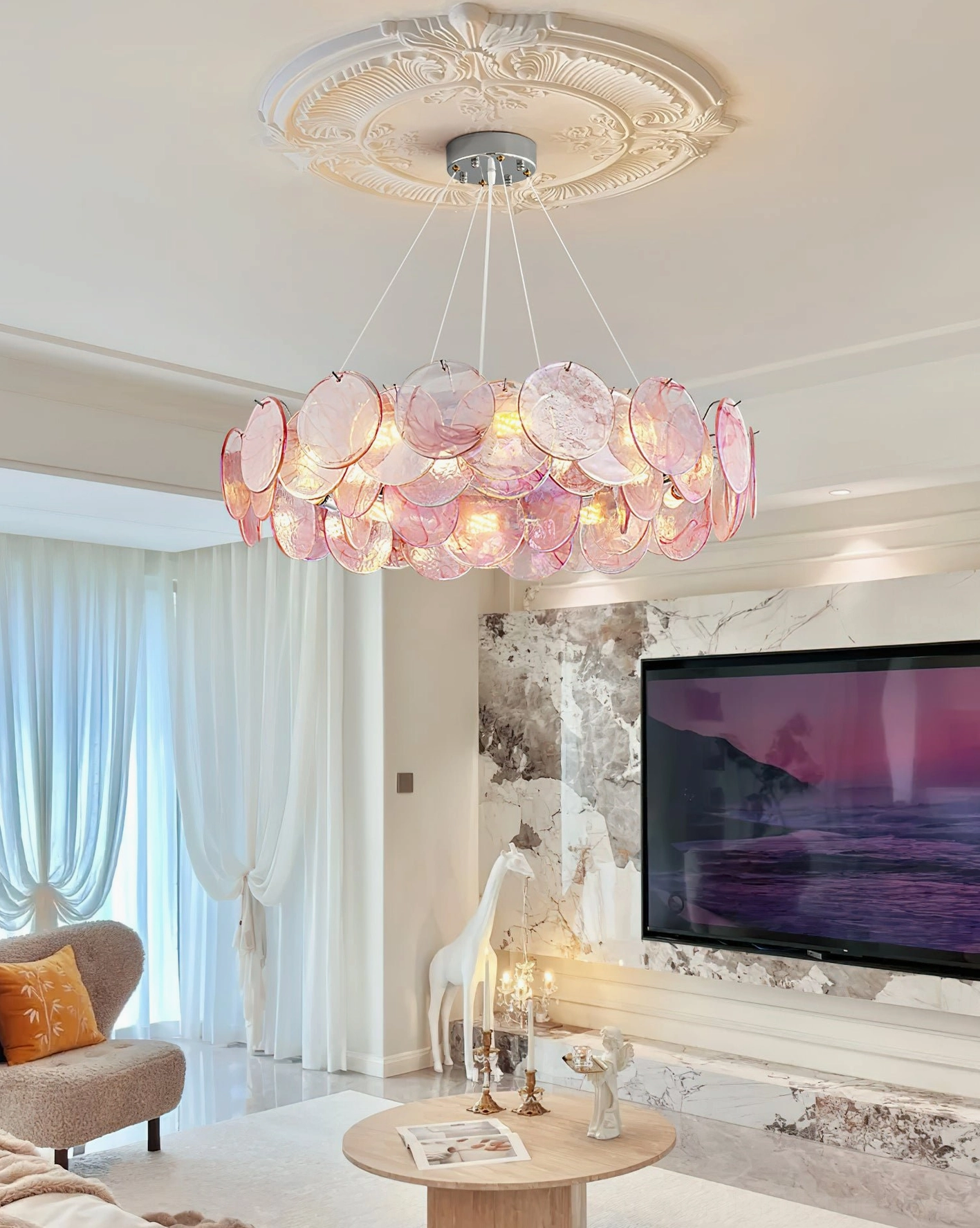 Contemporary pink disc chandelier installed on decorative carved ceiling medallion in modern luxury living room