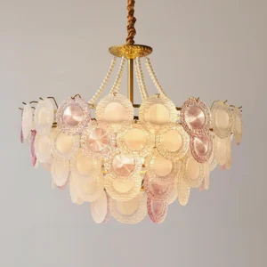 Violaire pink glass chandelier lit three-quarter view showing warm yellow light through frosted glass with pearl beaded chain
