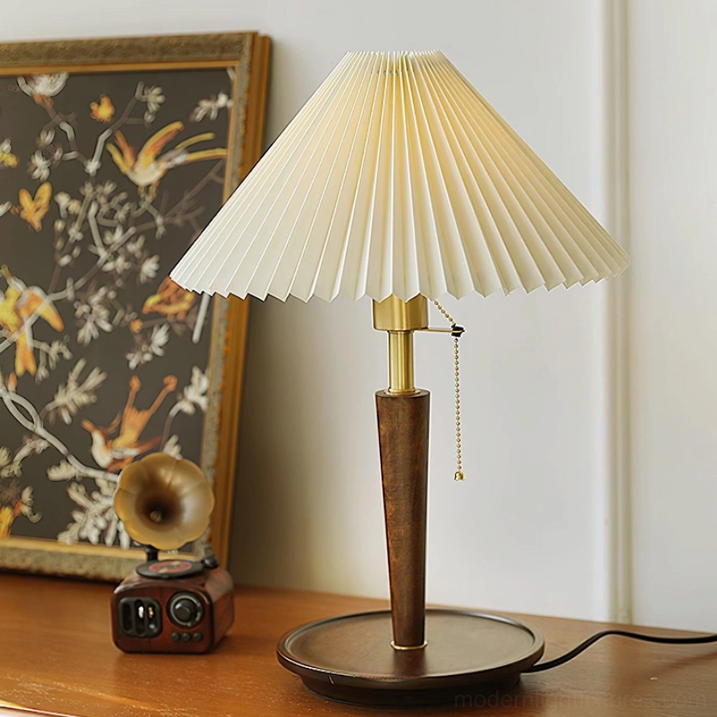 Mid-century modern pleated table lamp with gold hardware and pull-chain switch on wooden tabletop with vintage decor