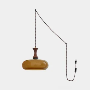 Modern amber glass plug-in pendant light with walnut wood fixture and twisted black power cord, studio shot on white background