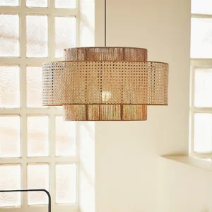 Modern rattan pendant lamp in interior setting with grid window, demonstrating warm ambient lighting and open-weave natural wicker design