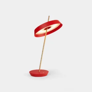 Red Poldina modern disc table lamp with brass golden stem and geometric base in minimalist studio setting